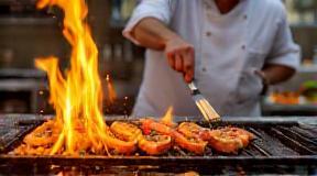 Chef grilling seafood in open kitchen